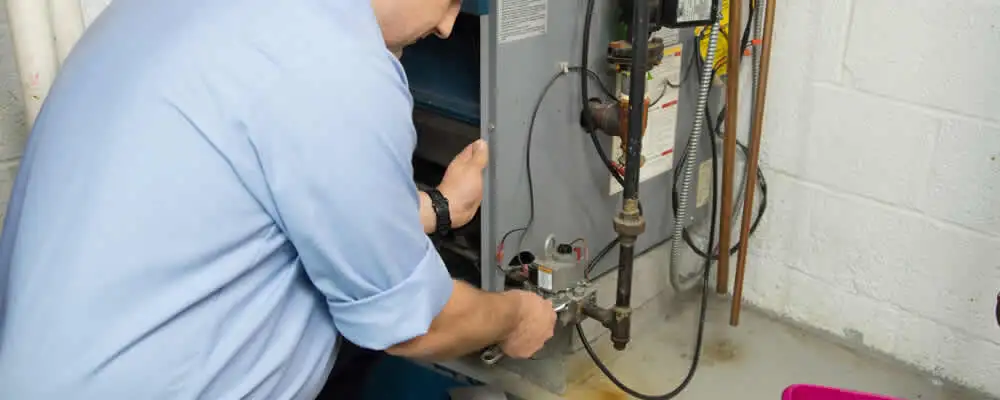 Furnace repair technician inspecting and servicing a home heating system in Kenosha, WI