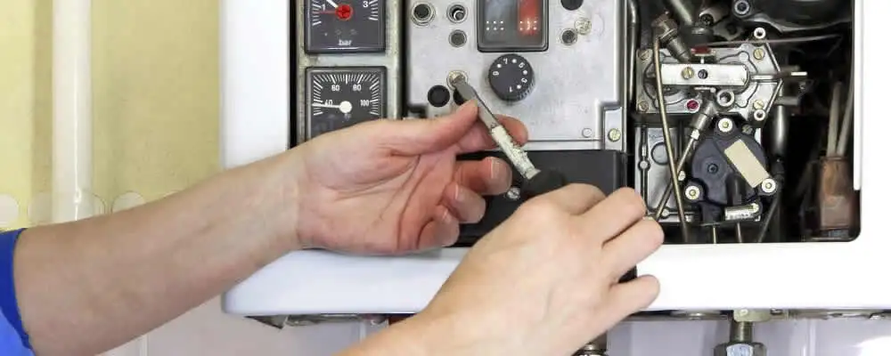 Heating repair technician adjusting boiler controls and components in Kenosha, WI