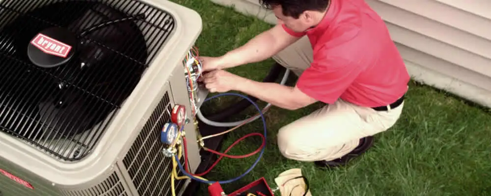 HVAC technician servicing an outdoor air conditioner unit in Kenosha, WI