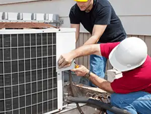 HVAC technicians repairing an outdoor AC unit on a rooftop in Kenosha, WI