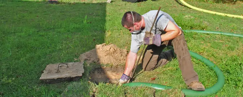 Septic pumping technician servicing a residential septic tank in Kenosha, WI